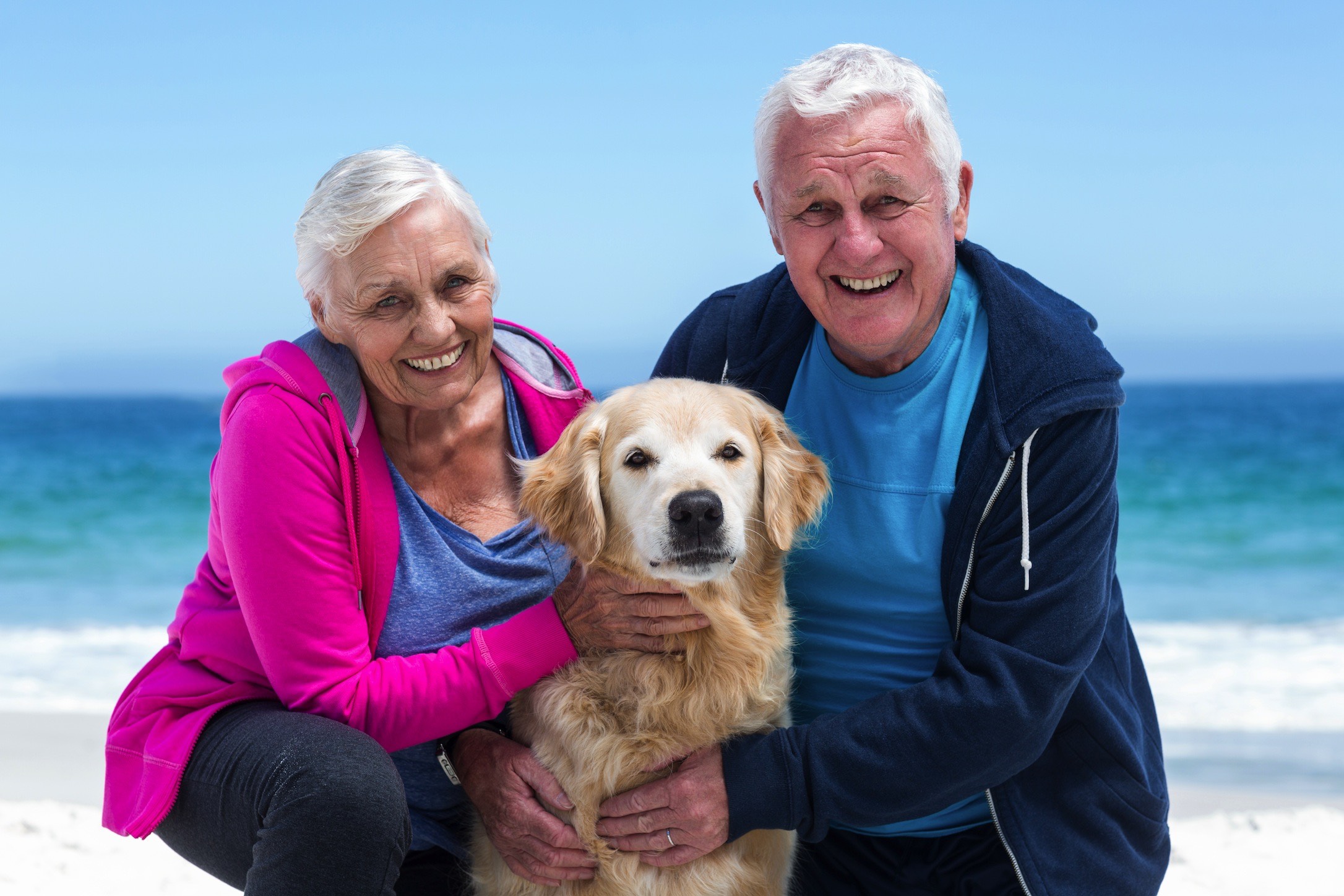 Older Couple on Beach with Dog